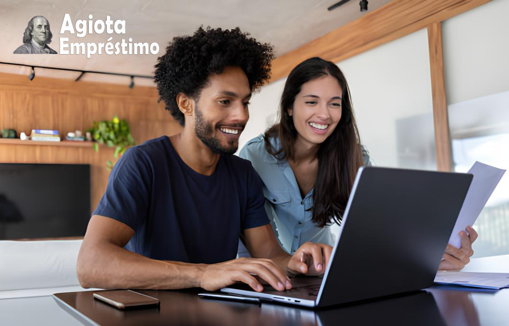 Casal sorridente olhando para a tela de um computador, simbolizando a confiança e a segurança na simulação de empréstimo online com a Agiota Empréstimo.